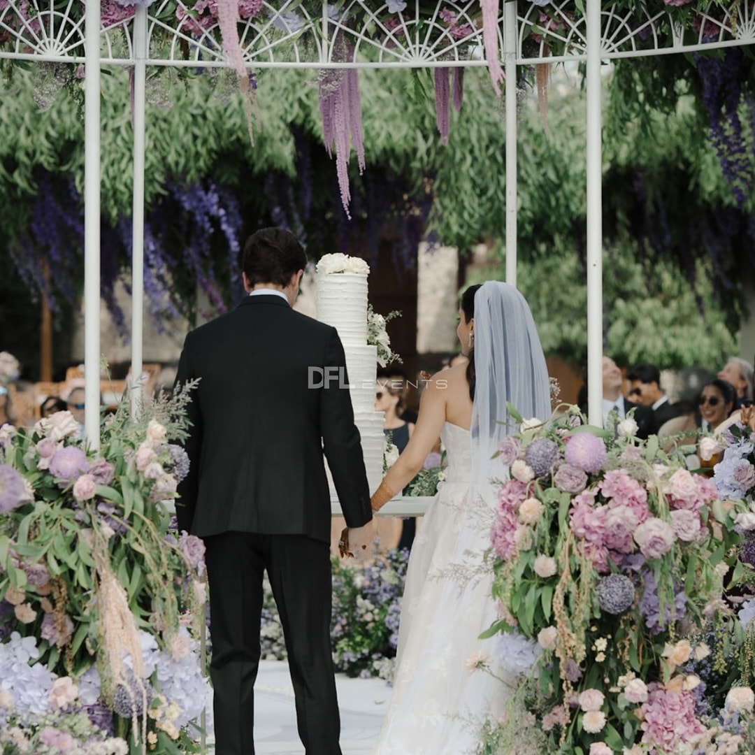 Couple walking under a floral wisteria arch in Bali