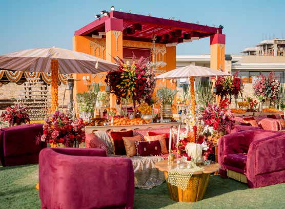 Rooftop wedding lounge decor in maroon and orange tones